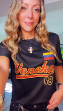 Load image into Gallery viewer, A woman wearing a black short-sleeve t-shirt with 'Veneka' and the number '58' printed in orange and yellow, featuring a Venezuelan flag patch on the chest.
